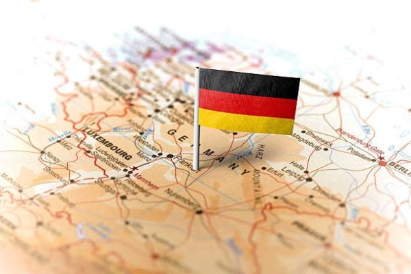The flag of Germany pinned on the map. Horizontal orientation. Macro photography.
